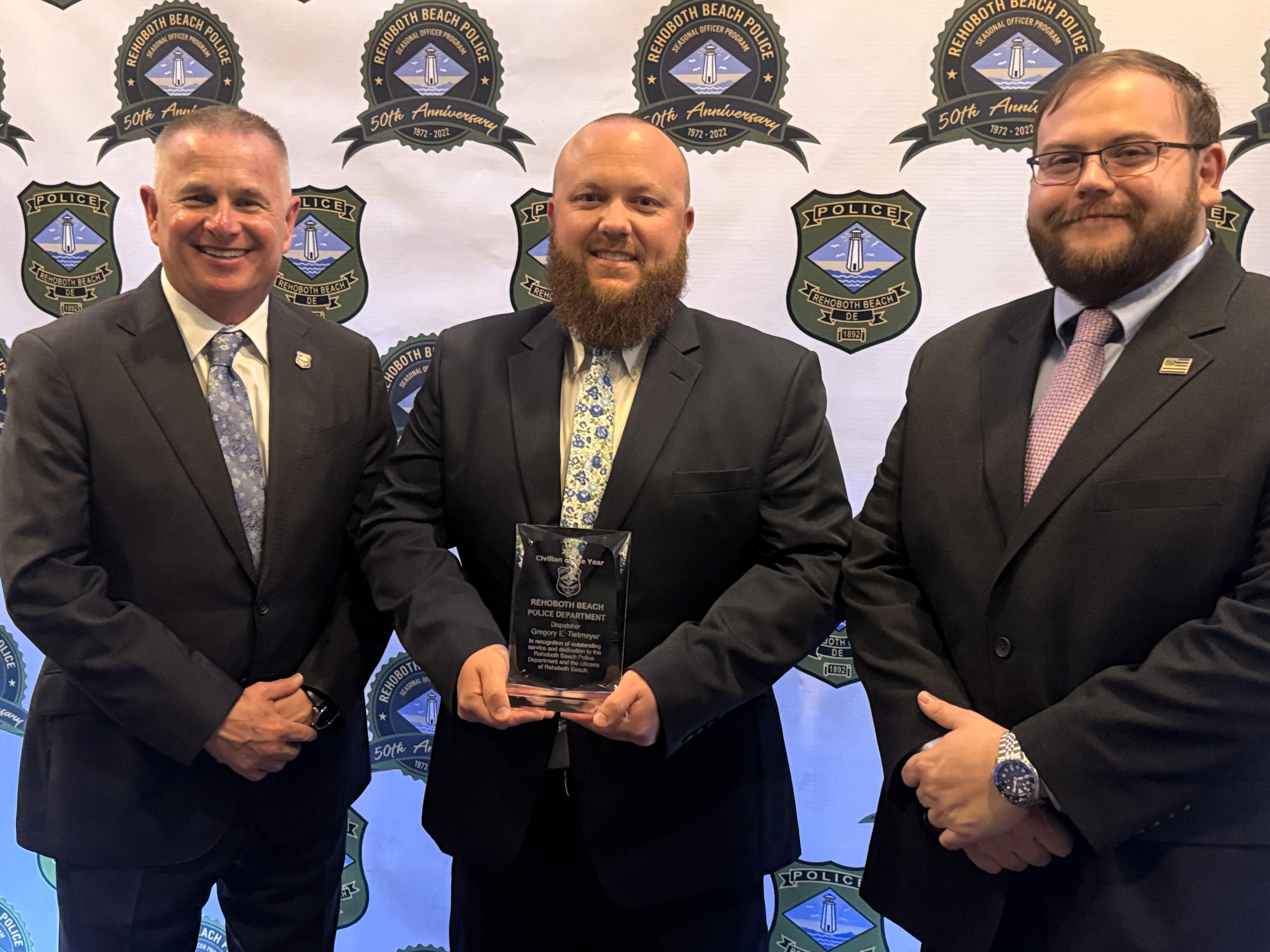 2024 Civilian of the Year Greg Tietmeyer in the middle holding his award with Police Chief Keith Banks on left and Communications Manager Nichols Priddy on the right