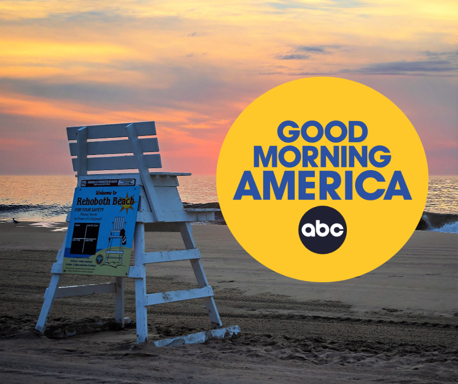 Image of sunrise on the beach with a lifeguard stand and a yellow circular logo that says 